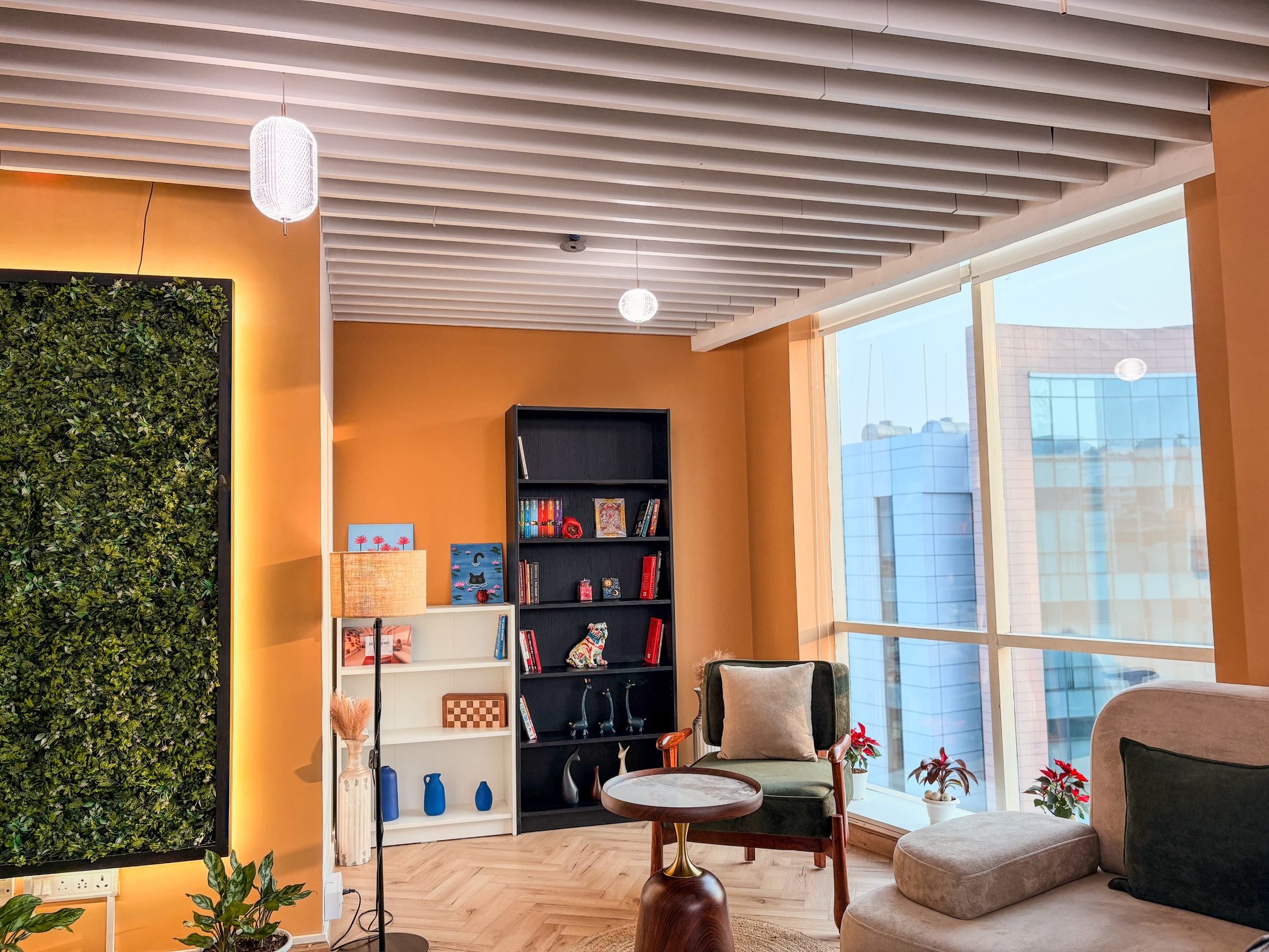 Quiet corridor at Limelight Coworks lined with private glass cabins and pendant lights